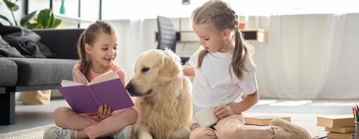 girls sitting on floor with dog